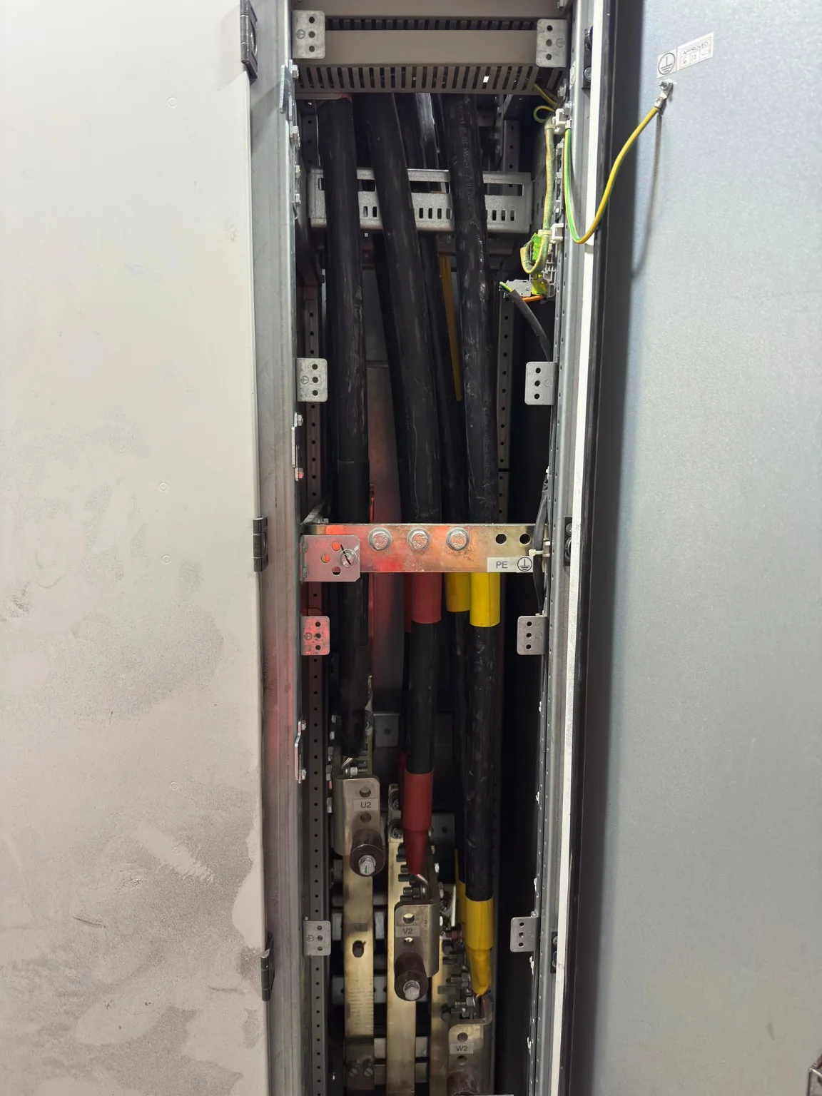 Elektrik dağıtım panosunda dikey yerleşimli güç kabloları ve bağlantı düzeni