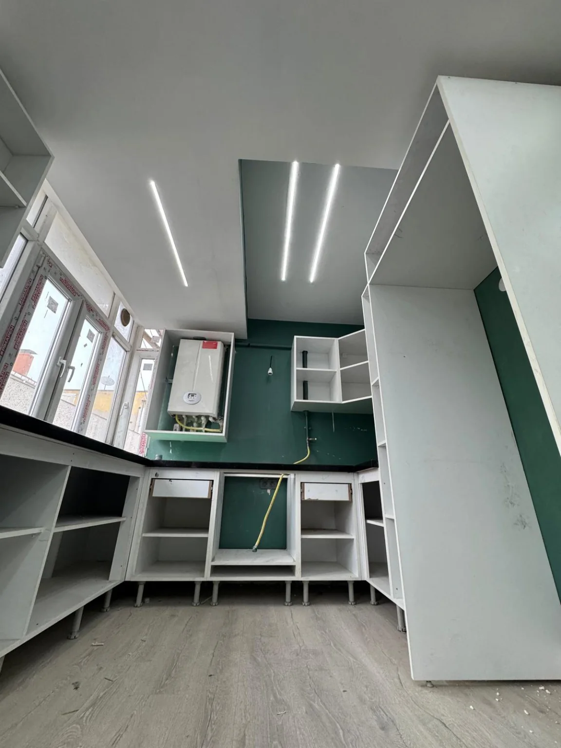 Mutfakta çalışma alanının üzerinde tavan boyunca yerleştirilmiş lineer LED ışıklar