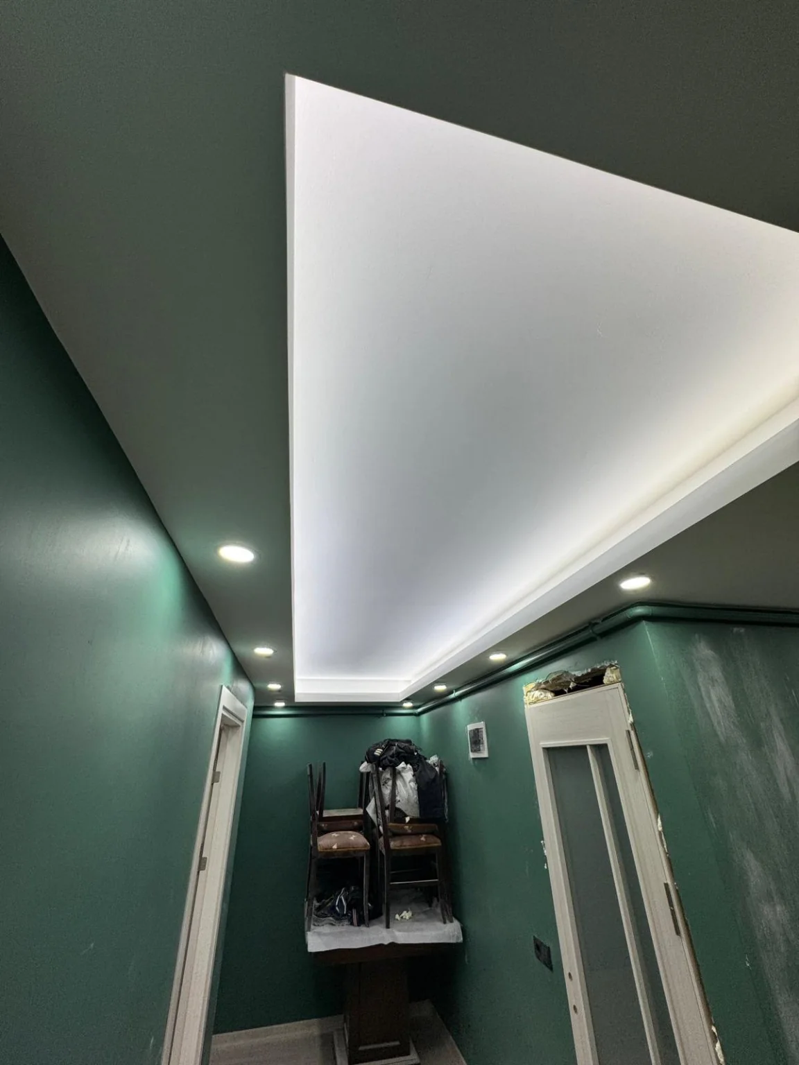 Uzun koridorda tavan çevresini izleyen gizli LED şerit ve spotlar